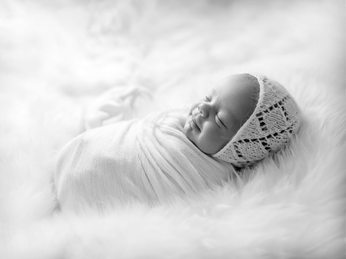 Natrual newborn photography in our studio near Redhill. Newborn baby sleeping on soft wool rug.