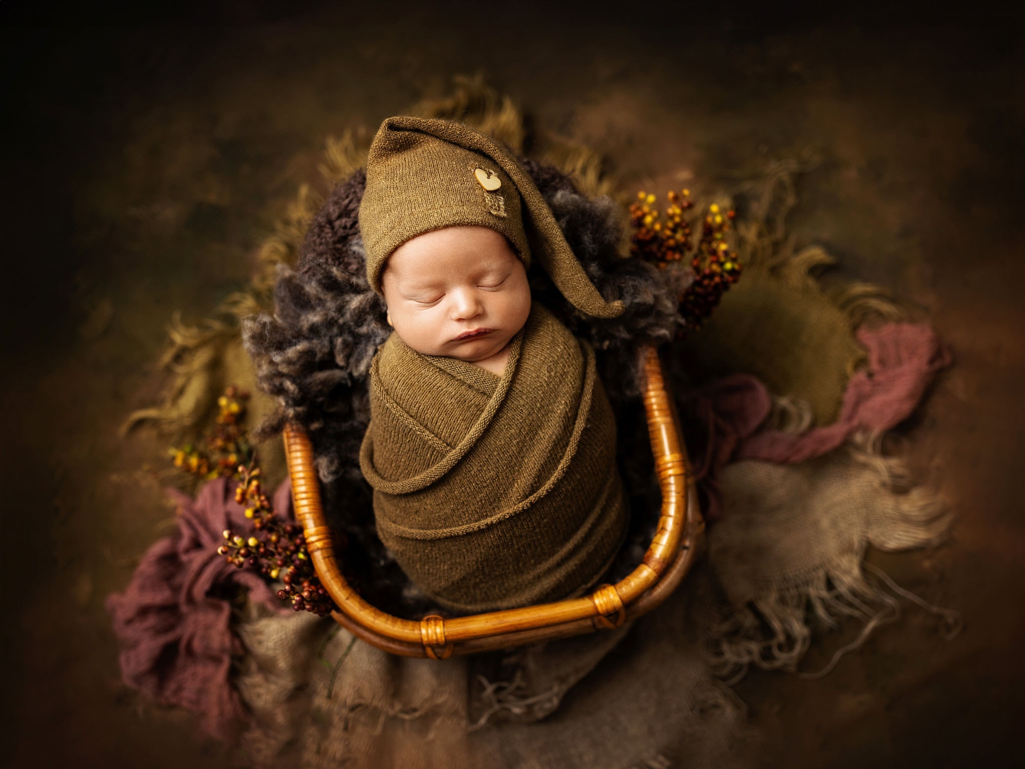 Fine art baby photography for parents in East Grinstead, featuring a newborn in a vintage-style photography basket.