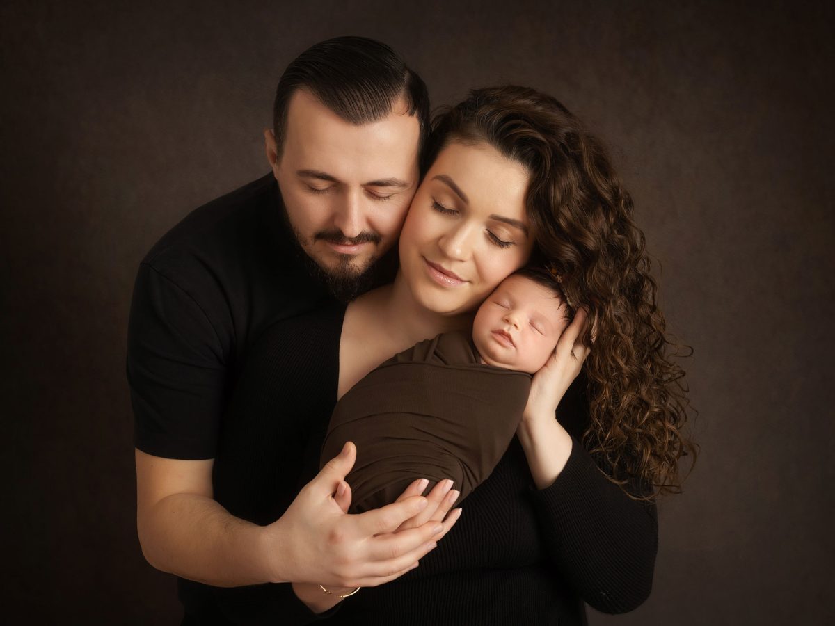Luxury newborn portraits for families in Dormans Park near East Grinstead, featuring parents holding their newborn baby. Newborn studio in Copthorne.