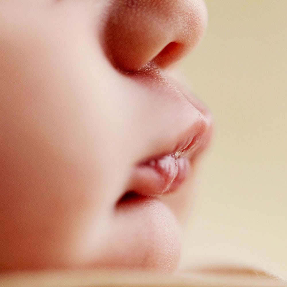 Newborn photographers for Redhill and Reigate, featuring close-up details of baby face with soft lips.
