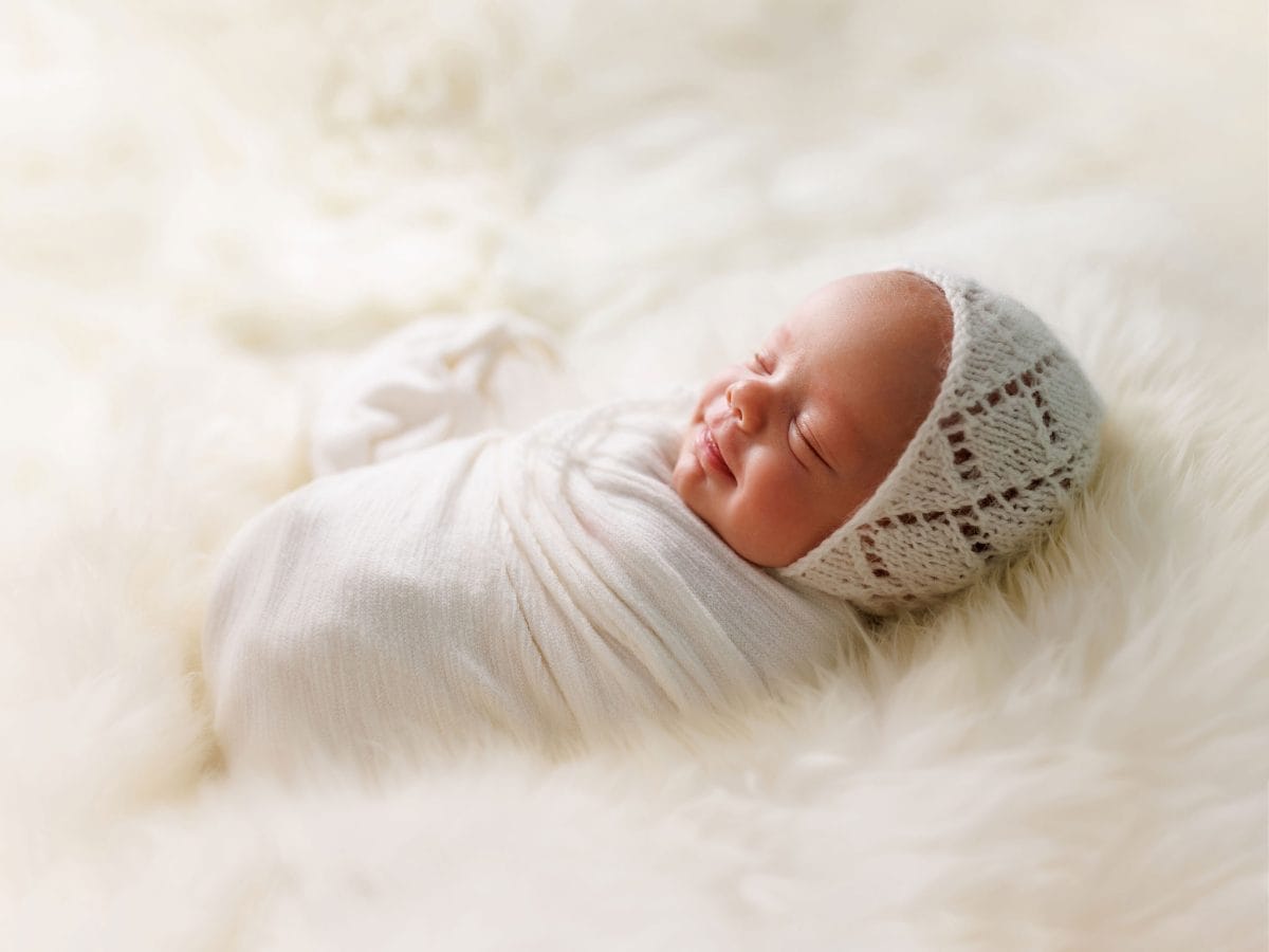 High-end newborn photography packages in Crawley: A baby sleeping soundly on a textured organic rug.