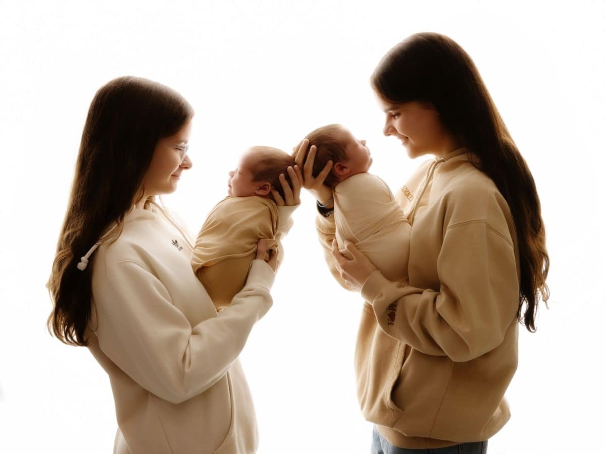 Sibling and newborn photography featuring twin girls holding newborn twin girls! Photoshoots for Oxted families at our boutique studio.