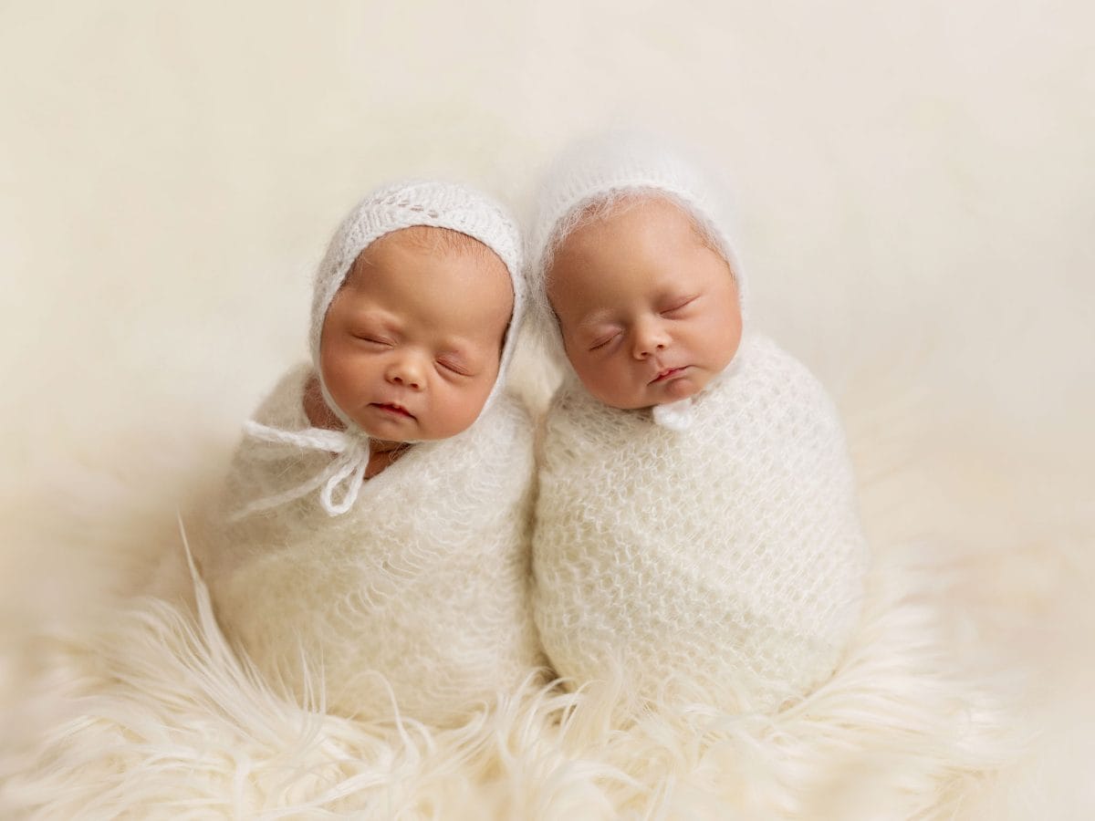 Sibling and newborn gallery for Haywards Heath families, featuring a pair of newborn twins posed together on a soft knitted blanket.