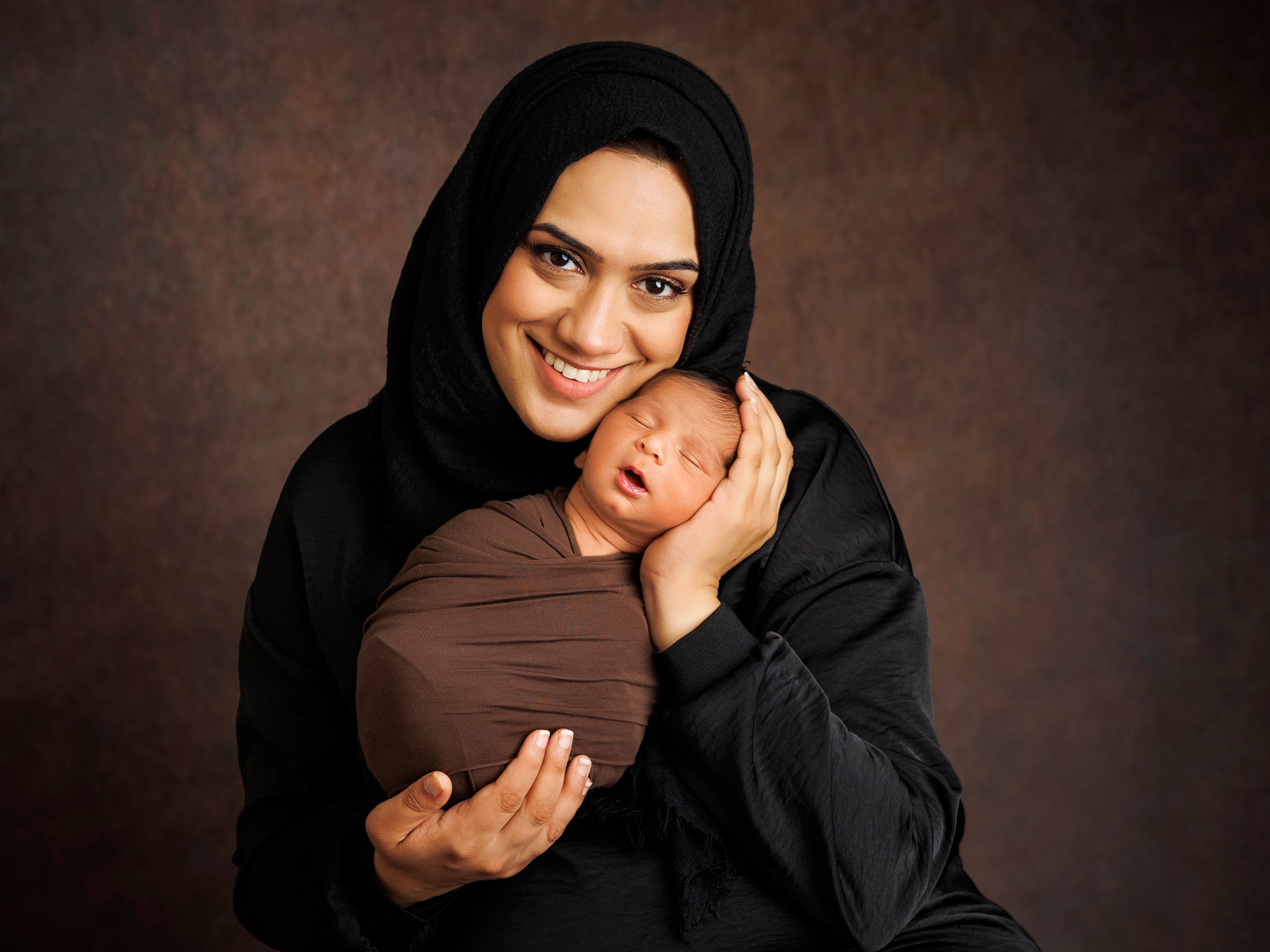 Calm newborn photography session with parents relaxed in studio environment